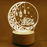 A warm white acrylic LED night light featuring an ornate crescent moon design with hanging lanterns, stars, and Arabic Eid-themed calligraphy. It sits on a round base and gives off a soft decorative glow.