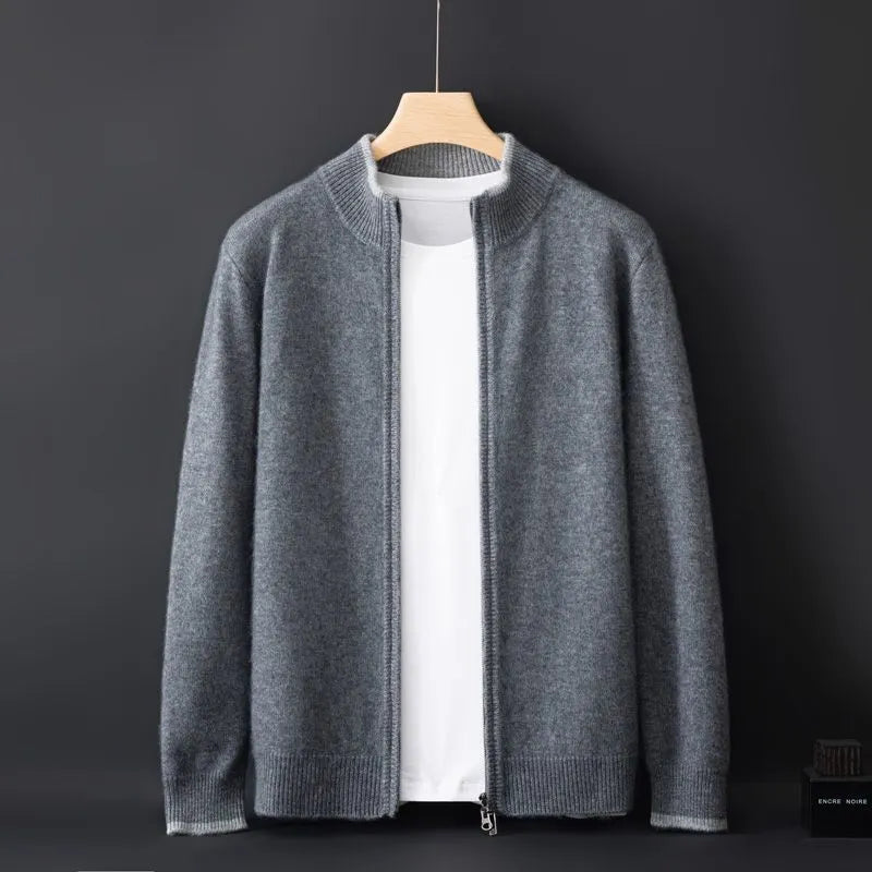 A gray zip-up cardigan with a ribbed collar, cuffs, and hem, layered over a plain white T-shirt, displayed on a wooden hanger against a dark background. The cardigan has a soft and cozy fabric, offering a versatile and stylish look for cooler weather.