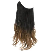 Long wavy hair extension piece in an ombré color, dark black at the top fading to light brown at the ends, shown on a white background.
