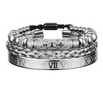 Stack of silver men’s bracelets featuring braided metal bands, bead accents, and a wide cuff engraved with Roman numerals, shown on a white background.