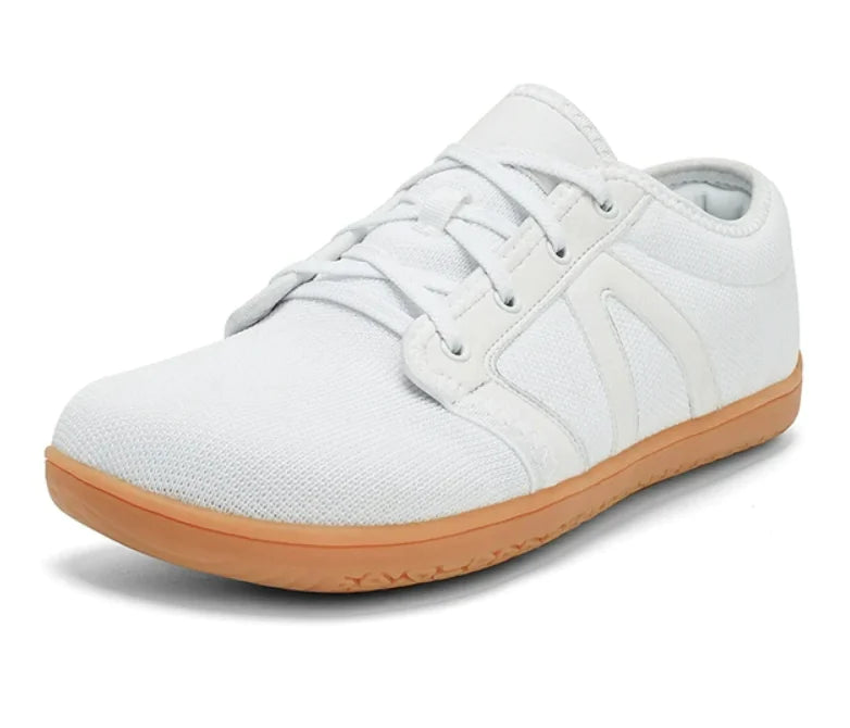 White-colored casual sneaker with a mesh fabric upper, lace-up design, black eyelets, and a white rubber sole
