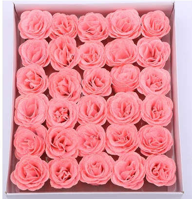 Pink artificial rose flower heads arranged in a display box.
