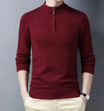  stylish burgundy slim-fit sweater with a quarter-zip collar, worn by a male model against a neutral gray background. The sweater has ribbed cuffs and a ribbed hem, ensuring a snug and modern fit. The model pairs it with light-colored trousers and a silver wristwatch, creating a refined and elegant look.