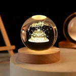 Glowing crystal ball night light on a wooden base with a 3D “Happy Birthday” design and cake inside.