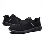 A pair of black athletic running shoes with a red interior lining and red accent along the midsole, featuring a breathable mesh upper and textured black rubber outsole for grip and flexibility.