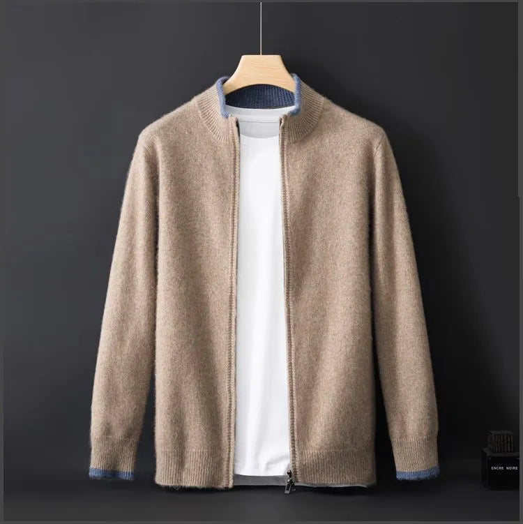 A beige zip-up cardigan with ribbed cuffs, hem, and collar, layered over a white T-shirt and displayed on a wooden hanger against a dark background. The collar and cuffs have subtle blue accents, adding a stylish contrast to the soft, cozy fabric.