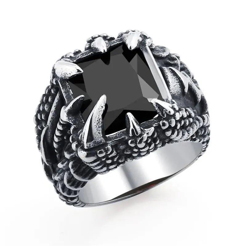 Silver-toned statement ring with a large faceted rectangular black gemstone set in corner prongs, featuring dark engraved side detailing, on a white background.