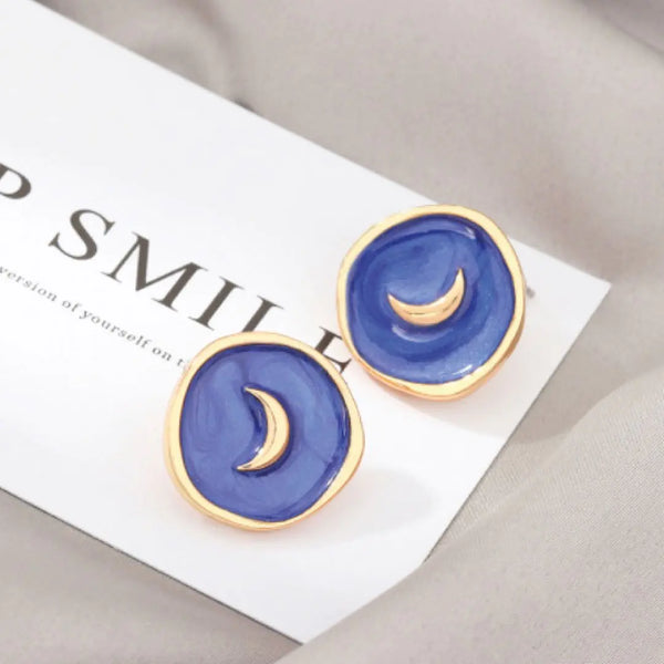 Close-up of navy Astral Earrings with celestial design