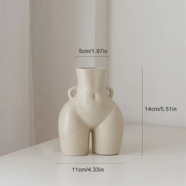 Cream ceramic vase shaped like a female torso, with small side handles and dimensions labelled 14 cm tall by 11 cm wide.
