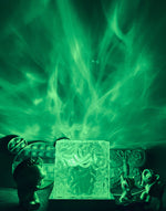 Green cube night light projecting aurora-style patterns onto the wall.
