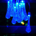 Blue raindrop-shaped LED string lights glowing against a dark background.
