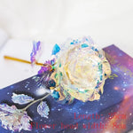 Iridescent crystal-style rose decoration with translucent petals and leaves resting on a starry book cover, with red text indicating “Length: 25cm” and “Flower head width: 8cm.