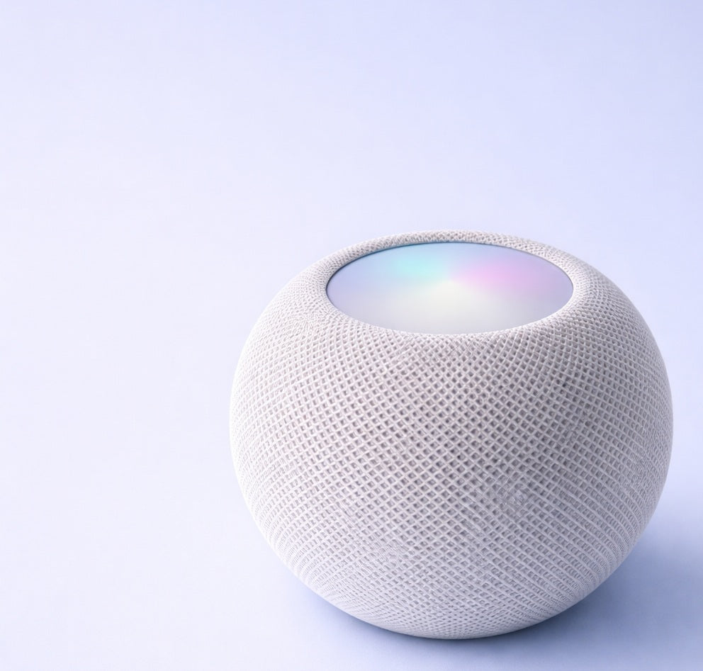 White smart speaker with a colorful display on a light purple background