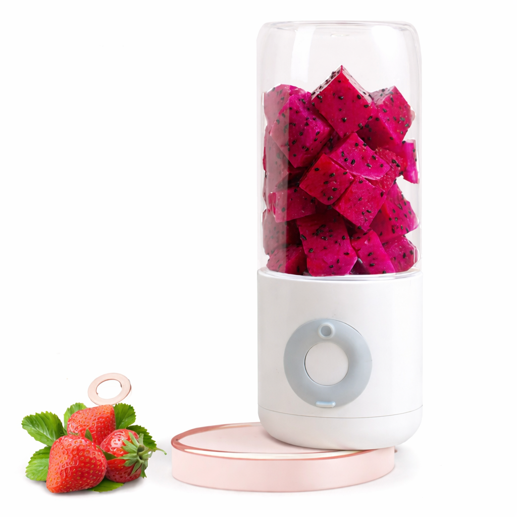 Small blender with dragon fruit pieces inside, surrounded by strawberries on a white background