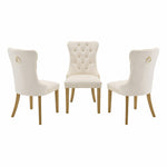 Three white upholstered chairs with gold accents on a white background