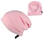 Light pink satin sleep bonnet with an adjustable strap, shown in two views on a white background.