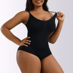 Person wearing a black seamless shapewear bodysuit with thin straps, pulling the fabric outward to show its stretch.