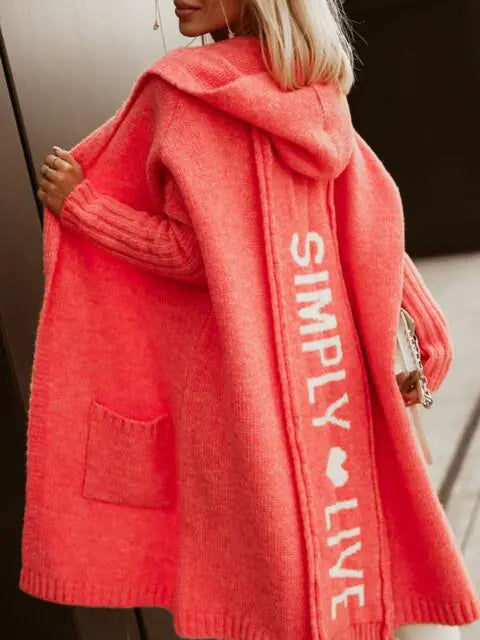Person wearing a red cardigan with 'Simply Live' text on a blurred background