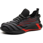 A black and dark gray athletic sneaker with a breathable knit upper, accented by bold orange wave-like stripes on the sides and orange detailing on the midsole. The shoe features a thick, textured sole and black-and-white patterned laces, designed for both style and performance.