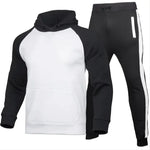 A stylish two-piece men's tracksuit. The set includes a hooded sweatshirt with a kangaroo pocket and long gray sleeves, along with matching jogger pants that have a drawstring waist and gray side panels with zippered pockets. The design offers a sporty yet casual look, ideal for workouts or everyday wear.