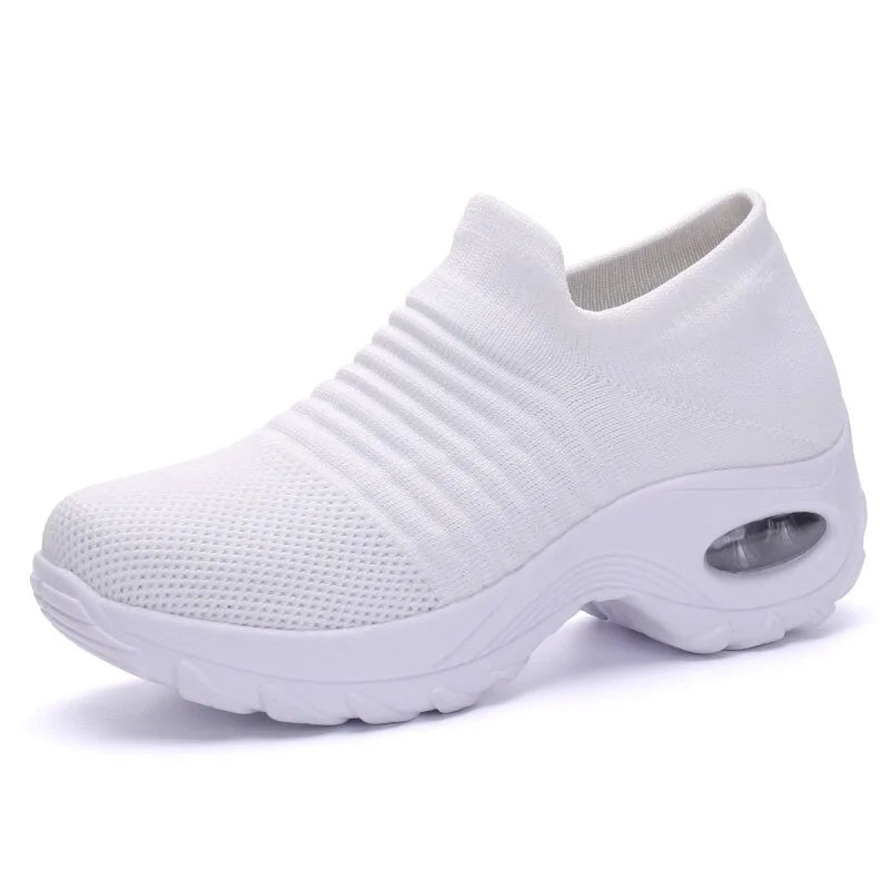 A vibrant red athletic sneaker featuring a breathable knit upper, lace-up design, and a unique, futuristic sole with hollowed cushioning pods for enhanced flexibility and support.