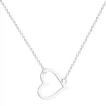 A delicate gold chain necklace featuring a tilted, hollow heart-shaped pendant. The heart is asymmetrically attached at both top curves to the chain, giving it a stylish slant. The background is plain white, highlighting the necklace's elegant and minimalist design.