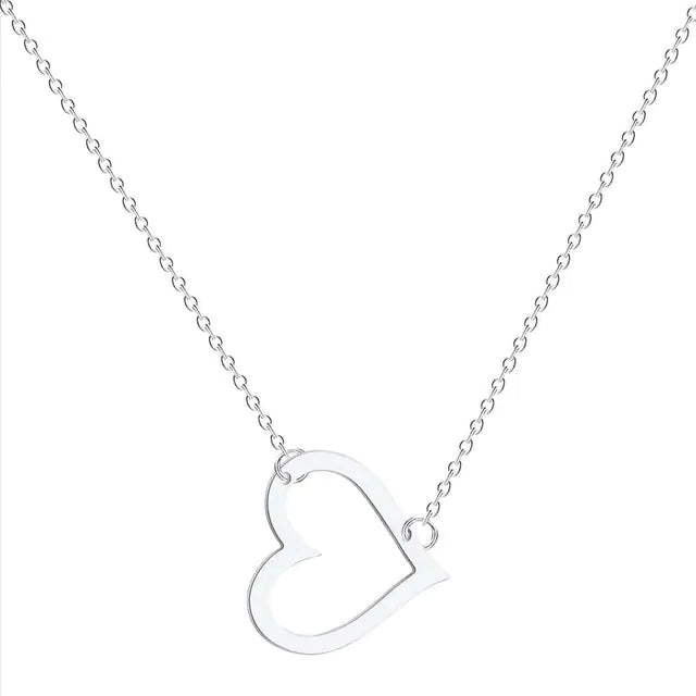 A delicate gold chain necklace featuring a tilted, hollow heart-shaped pendant. The heart is asymmetrically attached at both top curves to the chain, giving it a stylish slant. The background is plain white, highlighting the necklace's elegant and minimalist design.