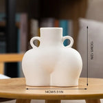 White ceramic body vase with a sculptural silhouette, loop side handles, and a compact decorative design measuring 14 cm wide by 13 cm high.