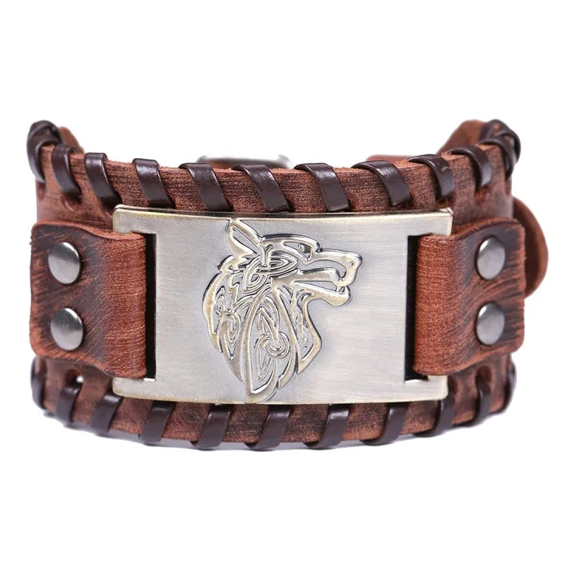 The image shows a brown leather bracelet with a woven design and metal embellishments. The centerpiece is a silver-colored metal plate featuring a wolf head design, which adds a rugged, tribal look to the bracelet.