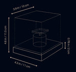 A dark background technical diagram showing a simple cube-shaped lamp or display cover on a rectangular base, drawn in thin outline lines with measurement arrows. Labels indicate approximately 3.9 in / 10 cm across the top, 4.6 in / 11.5 cm total height, 4.3 in / 11 cm base width, and 0.78 in / 2 cm base thickness, with a small cylindrical component shown inside.