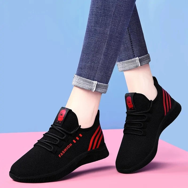 A pair of stylish mesh sneakers worn with jeans. The shoes feature colorful embroidered details The sneakers have a sleek, breathable design and a casual, trendy aesthetic.