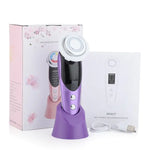 Purple handheld facial skincare device with a round metal treatment head, shown on a matching stand beside its floral product box, instruction booklet labeled “M8807,” and a USB charging cable.