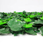 Close-up of artificial ivy garland with layered green leaves on a white background.