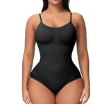 Woman wearing a black shapewear bodysuit with thin straps on a white background.