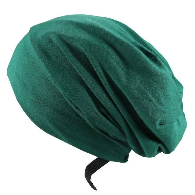 Dark green satin bonnet/hair cap with gathered folds and a black elastic strap, shown on a white background.