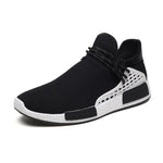 Black slip-on trainer with breathable mesh upper, wraparound laces and white contrast sole.
