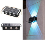 Collage showing a rectangular solar-powered wall light with three LED lenses: two product views with size measurements, and an installed example casting bright blue up-and-down beams on an exterior wall.