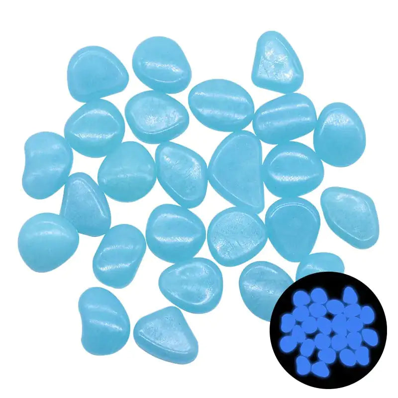A group of light-blue glow-in-the-dark pebbles scattered on a white background, with an inset showing them glowing bright blue in the dark.