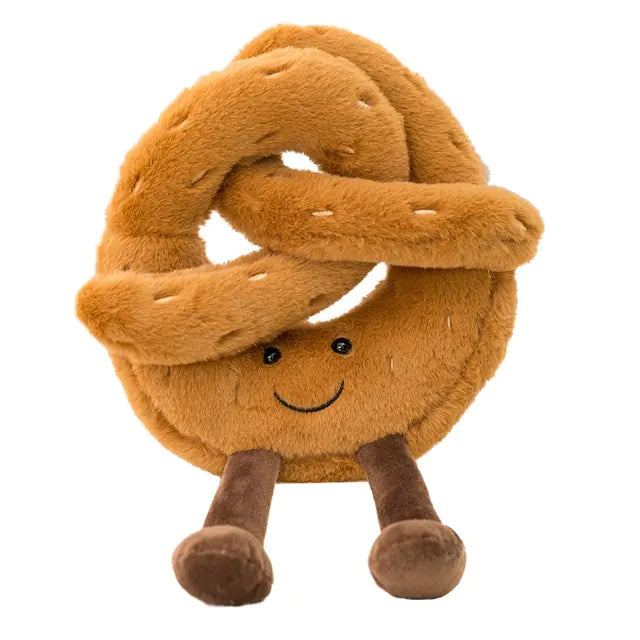 Smiling plush pretzel toy in tan/brown with stitched salt details and two dangling legs, shown on a white background.