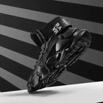 Black futuristic high-top trainers with chunky sole, elastic ankle cuff and bold strap detail.