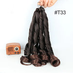 Hand holding a bundle of long, dark brown spiral-curled hair extensions labeled “#T33,” with a small vintage-style wooden radio beside it on a white background.