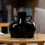 Blue ceramic body-shaped decorative vase with twin handles and rounded sculptural form.
