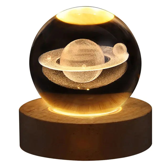 Glass crystal ball night light with a gold “cloud” and starry speckles inside, sitting on a wooden base against a dark background.