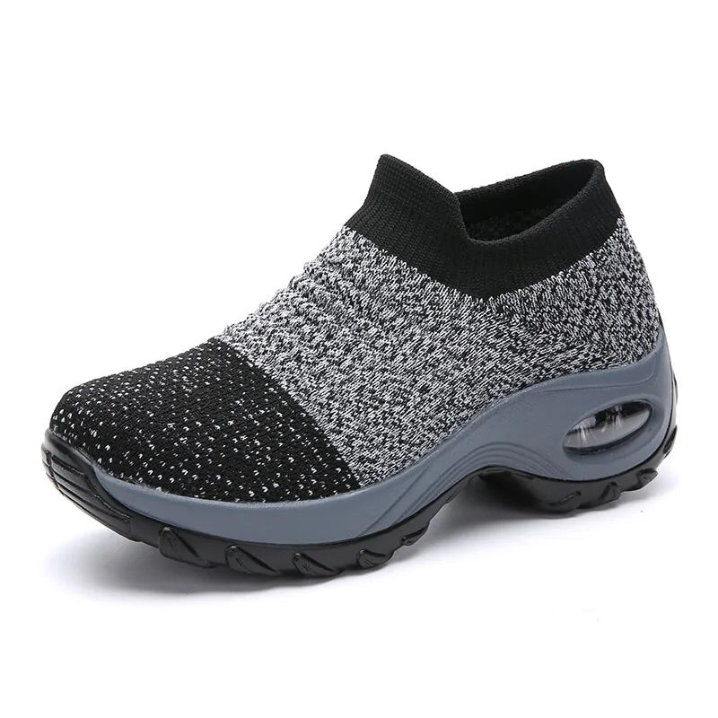 A vibrant red athletic sneaker featuring a breathable knit upper, lace-up design, and a unique, futuristic sole with hollowed cushioning pods for enhanced flexibility and support.