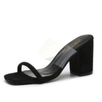 Black clear-strap block heel mules.