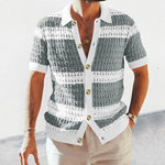 Man wearing a short-sleeved, button-up shirt with a crochet pattern in alternating white and grey stripes, paired with beige pants.