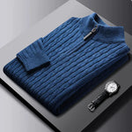 A neatly fold sweat shirt on a black surface with a black leather watch b the side