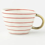 White ceramic mug with thin red horizontal stripes and a shiny gold handle on a white background.