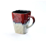 Red and silver ceramic mug with angular shape.