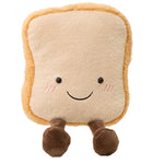 Smiling plush toy shaped like a slice of bread, with rosy cheeks and two small brown legs, on a white background.